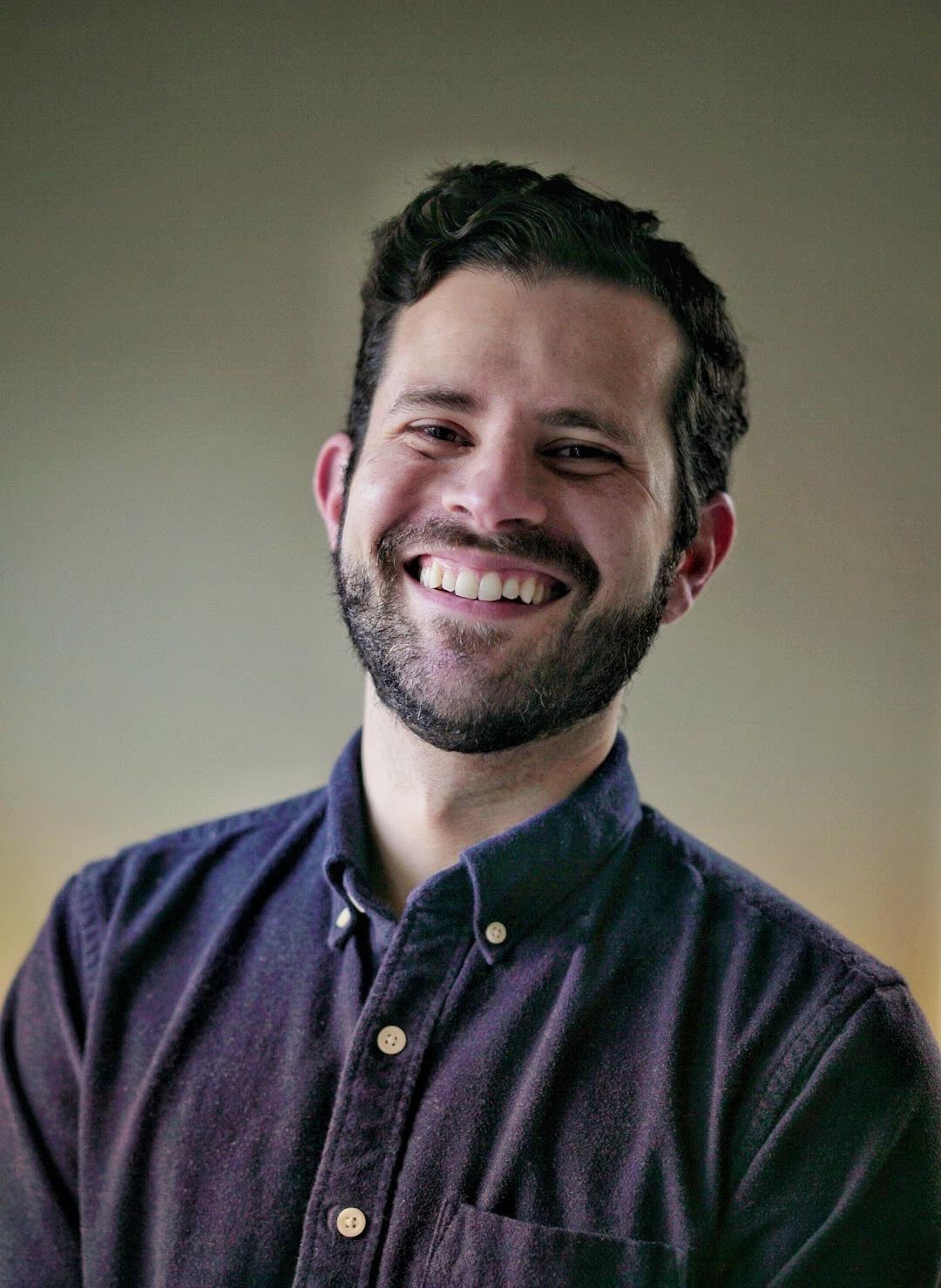 Mario Callejas, smiling, wearing a navy button-down shirt